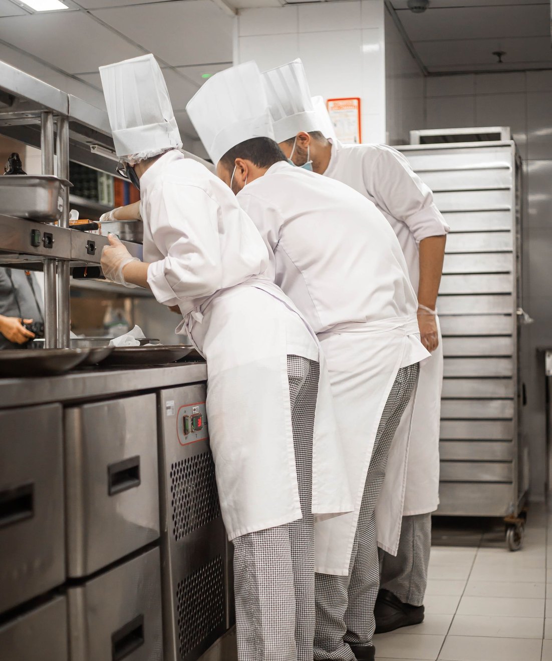 Cocineros con uniforme trabajando en una cocina profesional