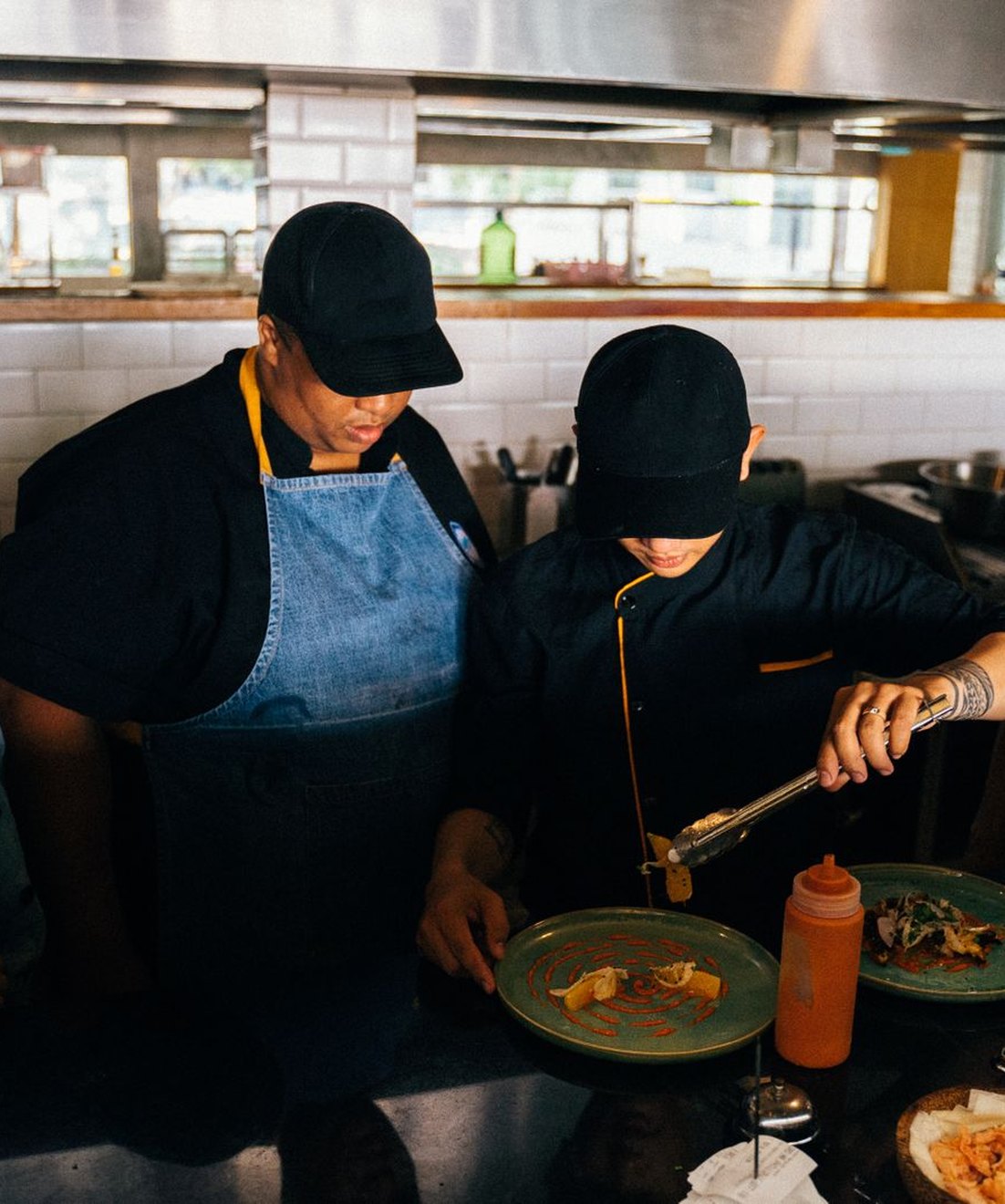 Jefe de cocina dirigiendo el acabado y emplatado de los platos