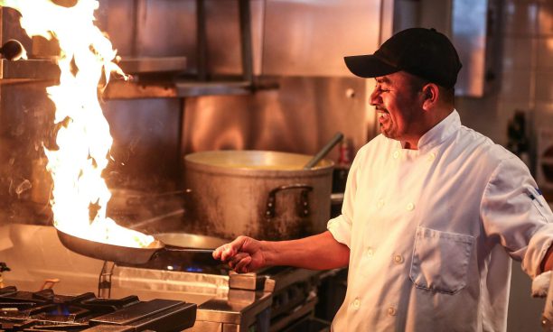 Cocinero trabajando ante los fogones